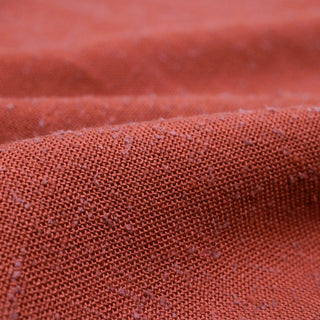 close-up image of rust slub hopsack fabric to show weave structure, sheen, and pill-like slubs
