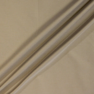 three diagonal lines of sand colored twill fabric, demonstrating the lightweight hand and matte face