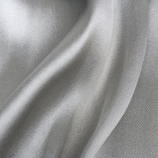 close-up of silver serge fabric made out of silk, detailing its twill weave