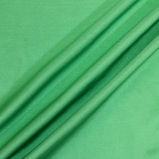 ruffle of spearmint green colored silk mikado fabric, demonstrating the lightweight hand and easy drapeability
