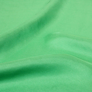 close-up of spearmint green colored silk mikado fabric, detailing the twill weave structure