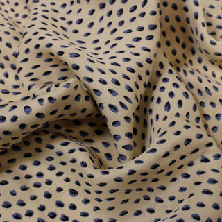 close-up of Beige silk chiffon fabric with slate blue spotted pattern