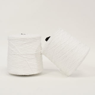 two large cones of stark white eyelash yarn, one leaning on the other