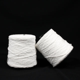 two large cones of stark white eyelash yarn, one leaning on the other