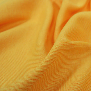 close-up of sunshine yellow colored 1x1 rib knit jersey fabric, detailing its knit structure and showing the weight of the drape