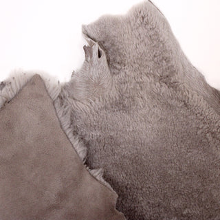 front and back of taupe colored shearling sheepskin hide. backing of suede that's more of a slightly mauve-grey color