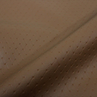 close-up of a tan colored pleather fabric embossed with a diamond-quilting-like pattern. subtle sheen to the surface