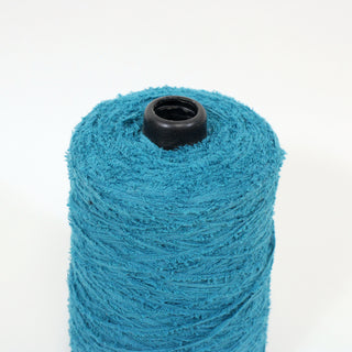 close-up of a small cone of teal colored eyelash yarn