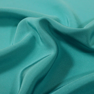 close-up of teal colored silk lining fabric, detailing the plainweave and subtle shine to the face