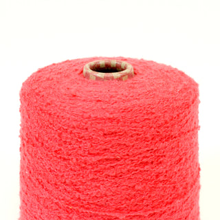 close-up of a cone of watermelon colored boucle yarn
