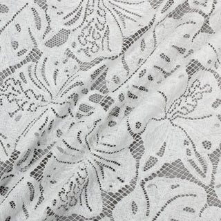 three diagonal lines across white botanical lace fabric, on a grey background