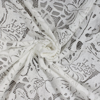 swirl of white botanical lace fabric against a grey background