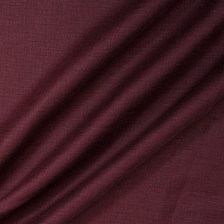 three diagonal draped lines of a burgundy colored linen upholstery fabric with a slub texture woven throughout creating a cross-hatch-like effect