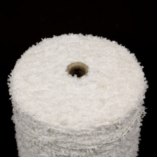 Close up of a white eyelash yarn cone on a black bacground.
