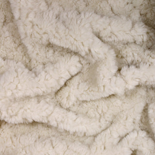 Close up of a cream long pile faux fur, detailing the drape and surface shine.