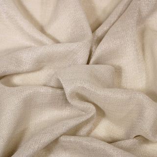 Close up of a glittery beige gauze fabric, detailing the drape and surface shine.
