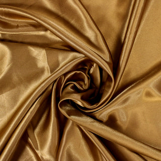 Swirl of a gold poly satin fabric, detailng the drape and surface shine.