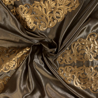swirl of a satin applique pleather fabric, demonstrating the drape and shine of the fabric