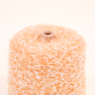 Closeup of grapefruit pink loop yarn on a white background.