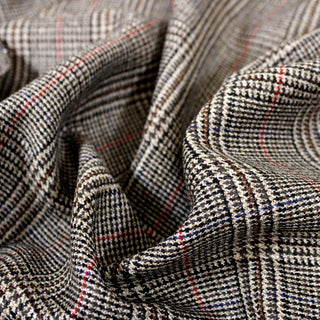 Closeup of a houndstooth plaid suiting, detailing the surface shine.