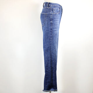 side view of blue jeans on a mannequin against a white background
