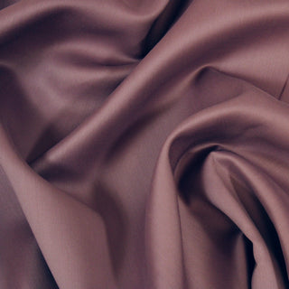 Close up of mauve bengaline fabric, showcasing the drape and surface shine.