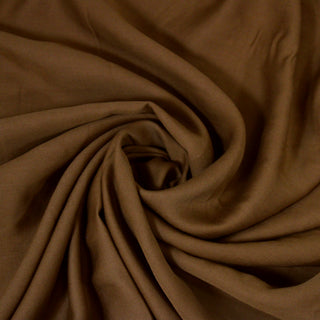 Swirl of a brown shirting fabric, detailing the surface shine and drape.