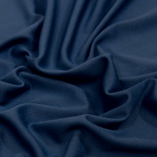 Close up of a blue tricot knit fabric, detailing the texture and surface shine.