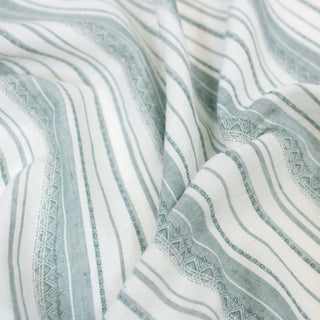 close up of a green and white striped shirting fabric, detailing the surface shine.