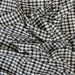 Close up of a pink black plaid fabric, detailing the surface shine.