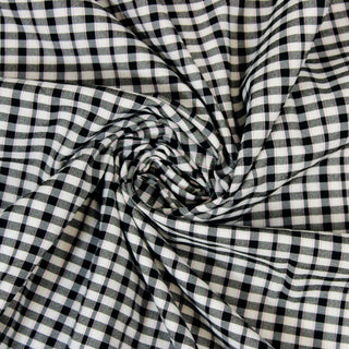 Swirl of a pink black plaid fabric, detailing the surface shine and drape.