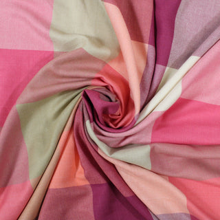 swirl of a pink multi plaid flannel, demonstrating the drape and shine of the fabric