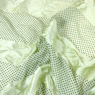 Closeup of a pistachiogreen satin fabric, detailing the surface shine.