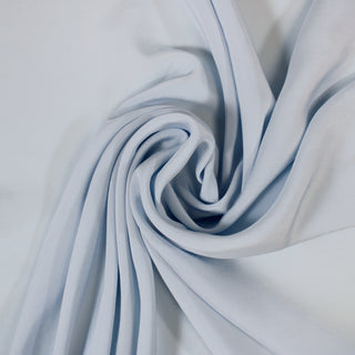 swirl of a powder blue rayon crepe, detailing the surface shine and drape of the fabric