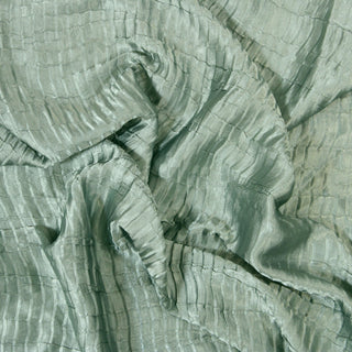 Close up of a plisse satin fabric, detailing the surface shine and drape.