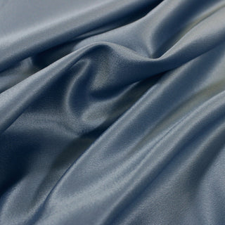 Close up of a blue polyester satin fabric, detailing the surface shine.
