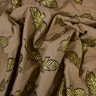 Close up of a brown plain weave fabric with brocade feather embroidery, detailing the drape  of the fabric.