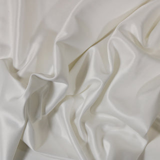 Close up of a white charmeuse fabric, detailing the surface shine and drape.