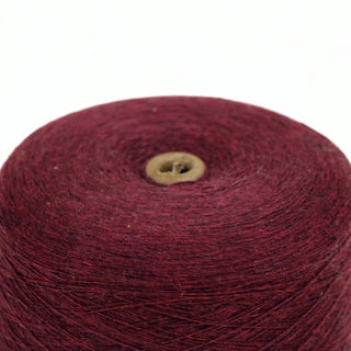 Close up of red wool yarn on a white background, detailing the texture/
